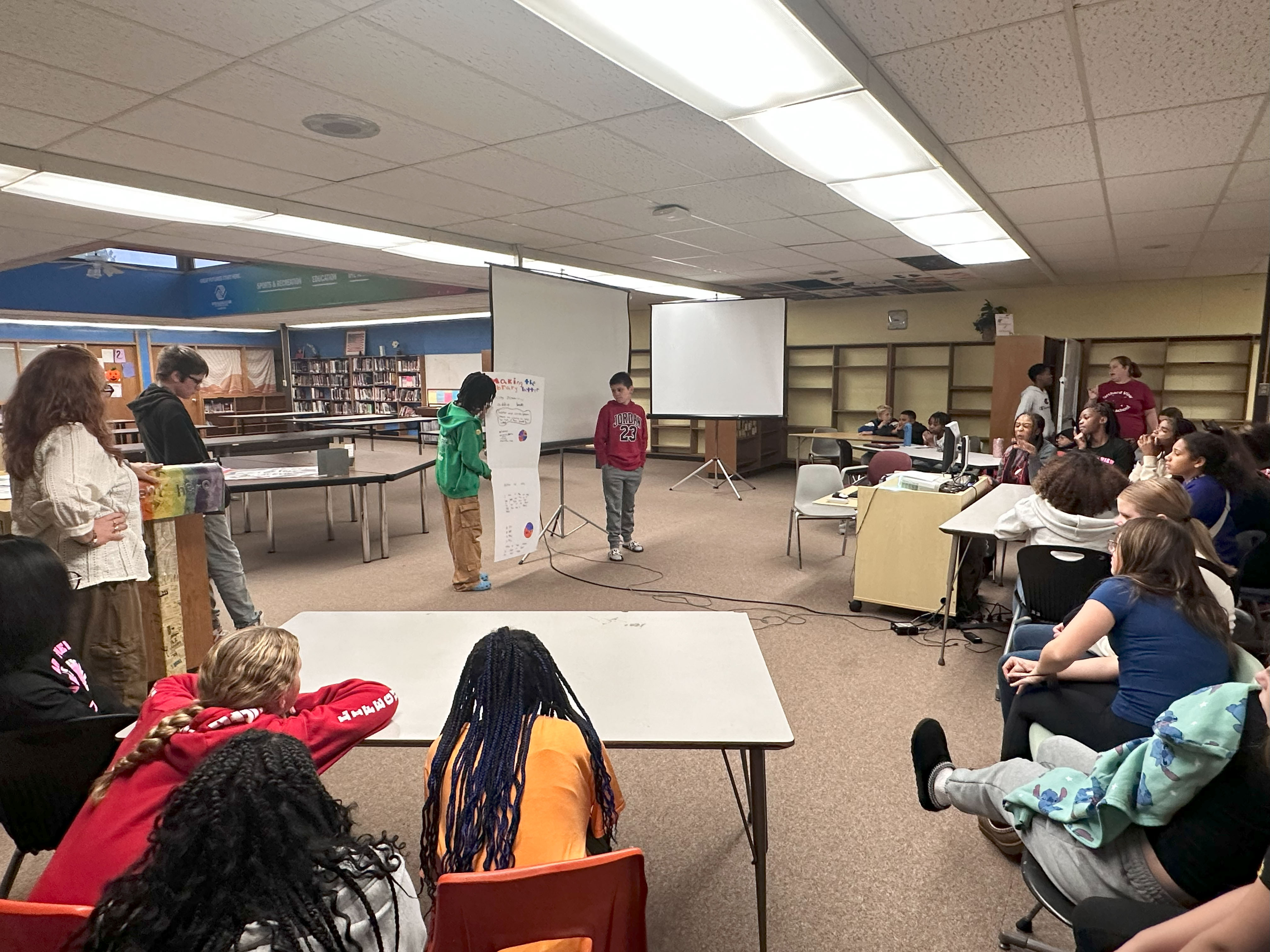 A group of students presenting to a large group about their space proposal.