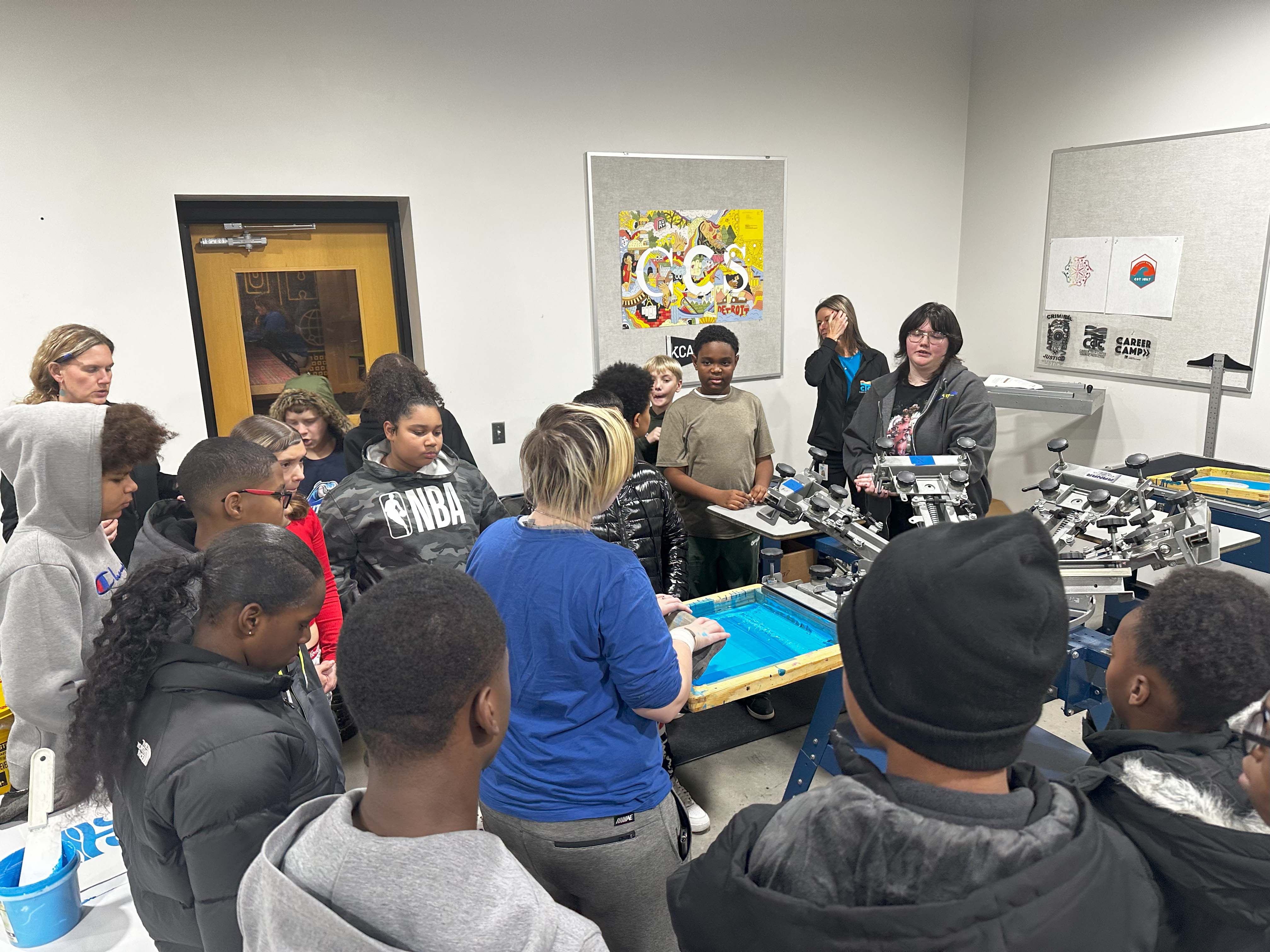 Students operating a screen printer.