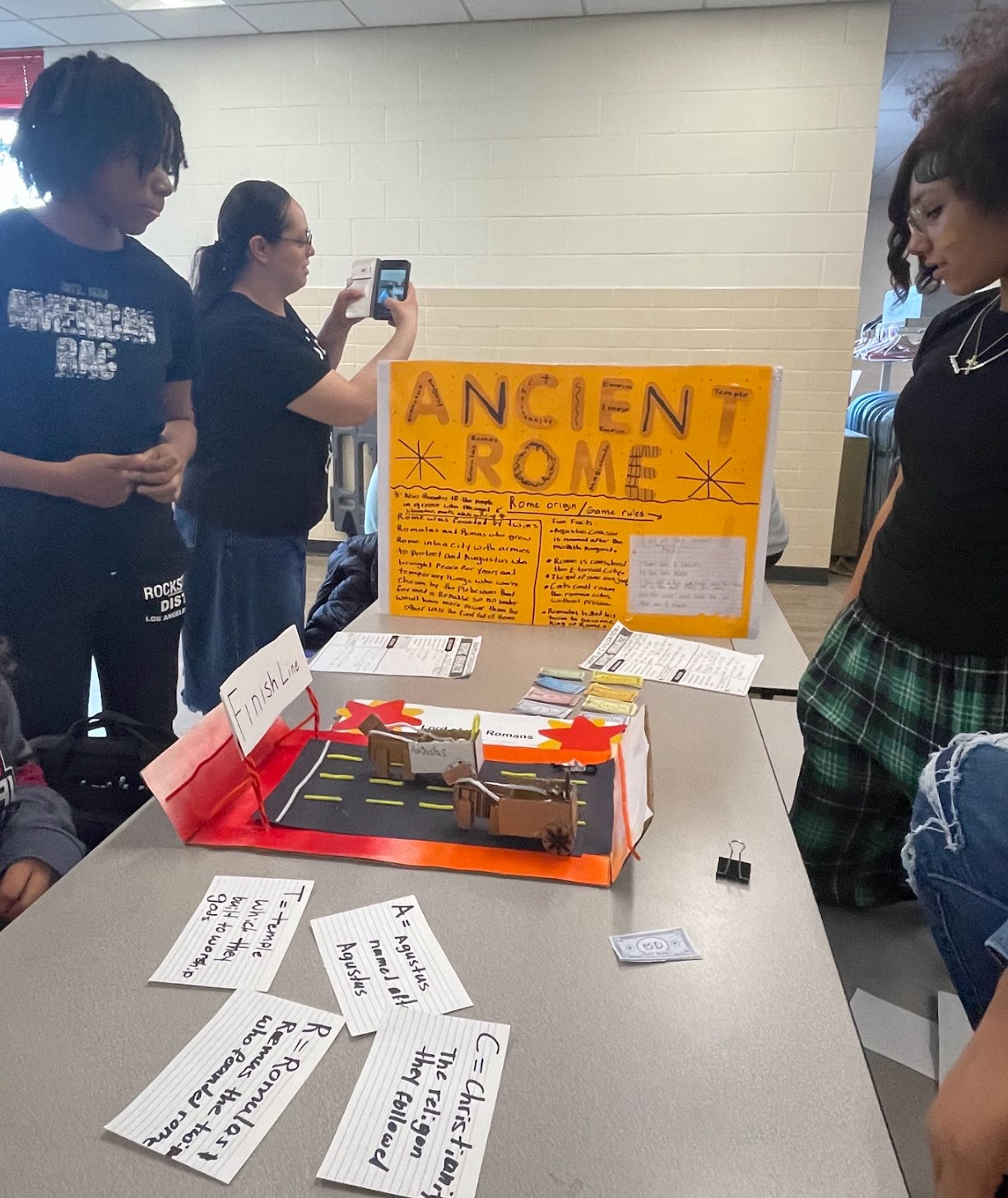 Students presenting on ancient Rome via a board game.